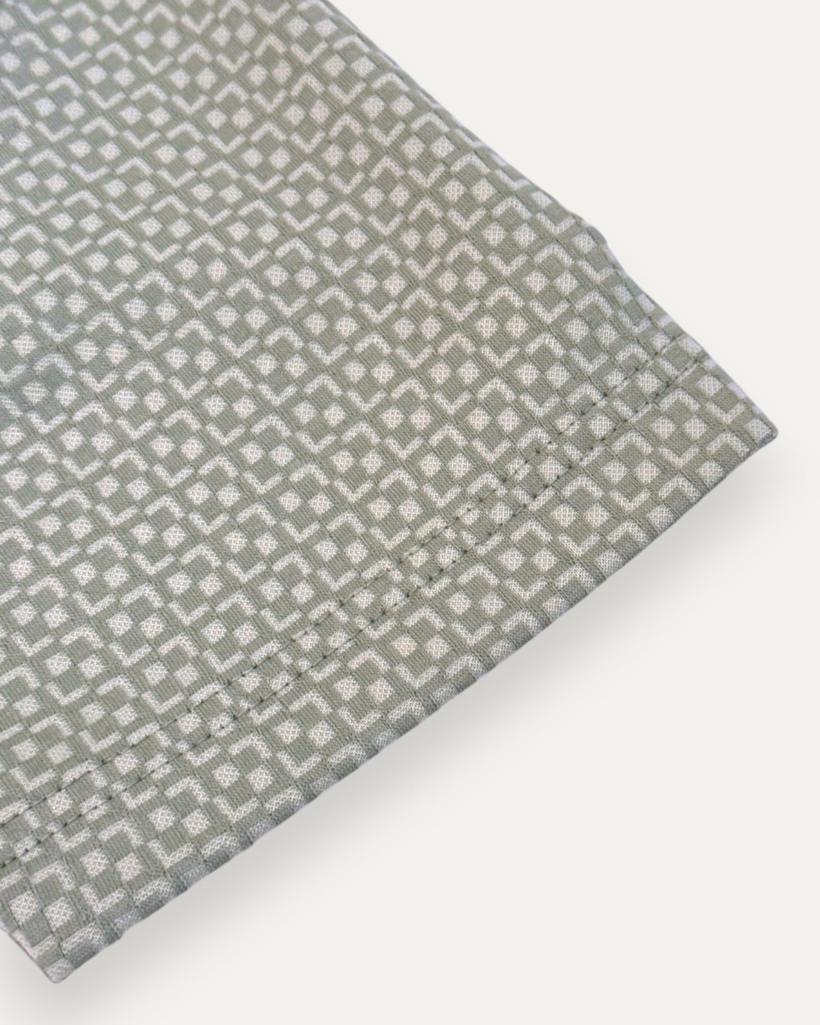 Green textured fabric with geometric pattern on a white background